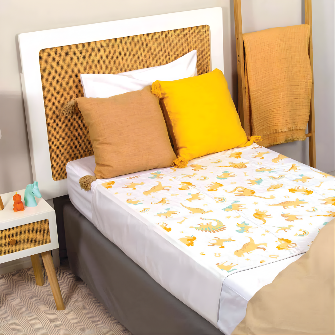 Conni Kids Bed Pad Unicorn & Dinosaur, available in standard and tuck-in variants, reusable waterproof protection for children’s nighttime comfort.