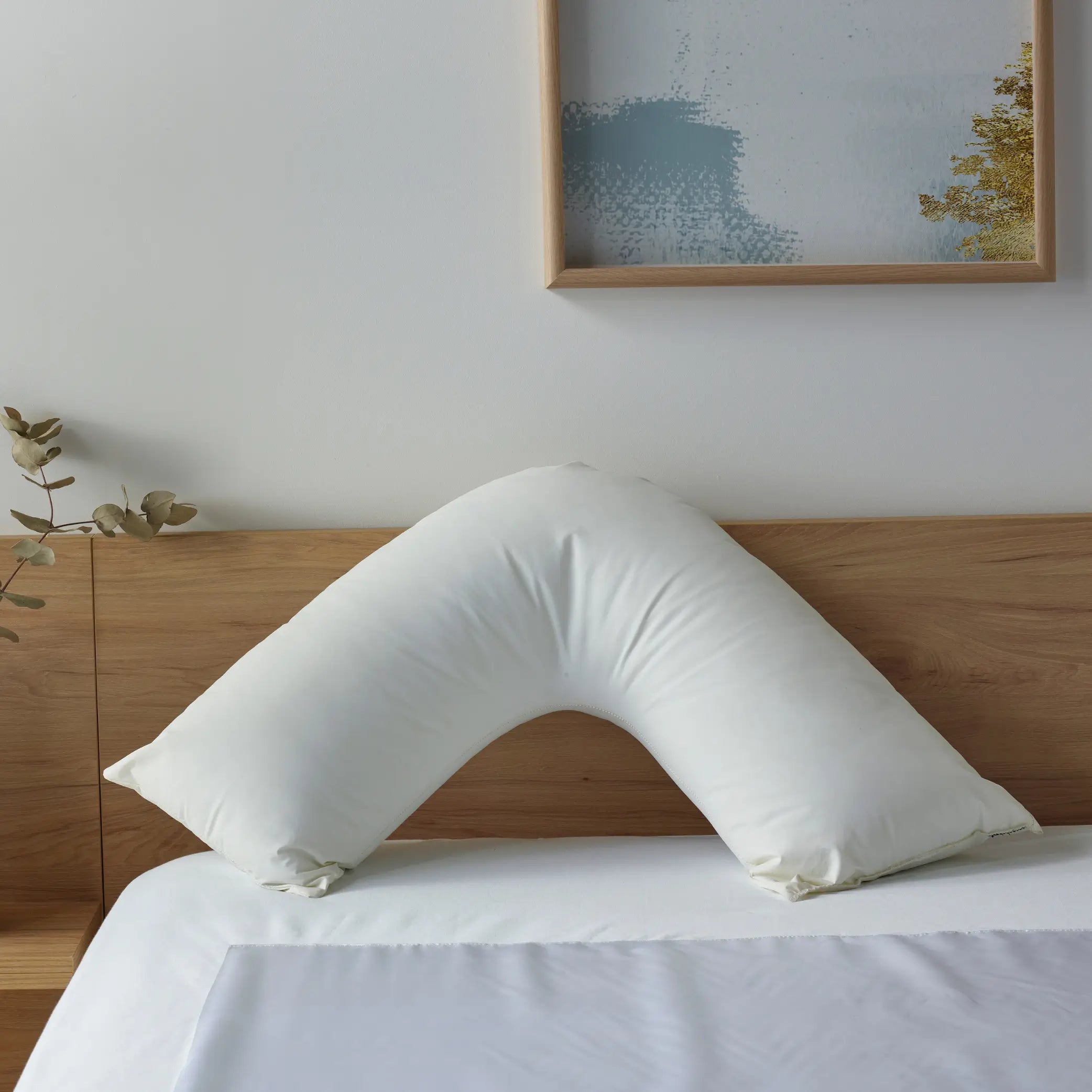 Duratherme Waterproof Boomerang Pillow placed on a bed, featuring a liquid-resistant, hypoallergenic design for superior comfort and support. This ergonomic V-shaped pillow provides optimal neck and back support, ideal for pregnancy, reading, and relaxation.