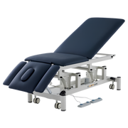 Five-section medical treatment couch with postural drainage capability, adjustable headrest, and independent armrests. Electric height-adjustable physiotherapy table by ComfyCare on a white wheeled base.