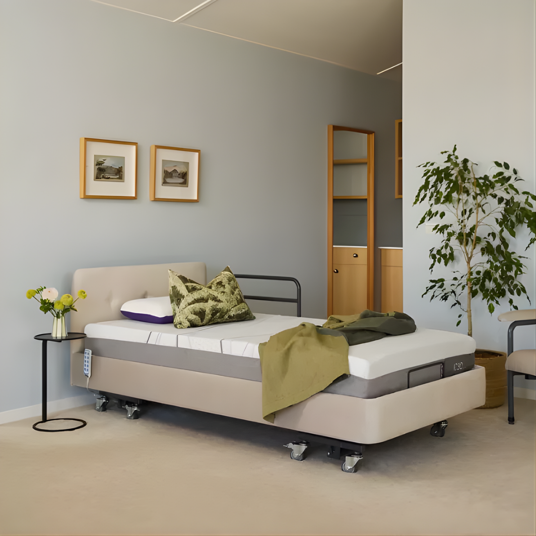 Icare IC333 Homecare Bed shown with adjustable backrest and leg rest, featuring upholstered finish and ultra-low height for safe mobility.