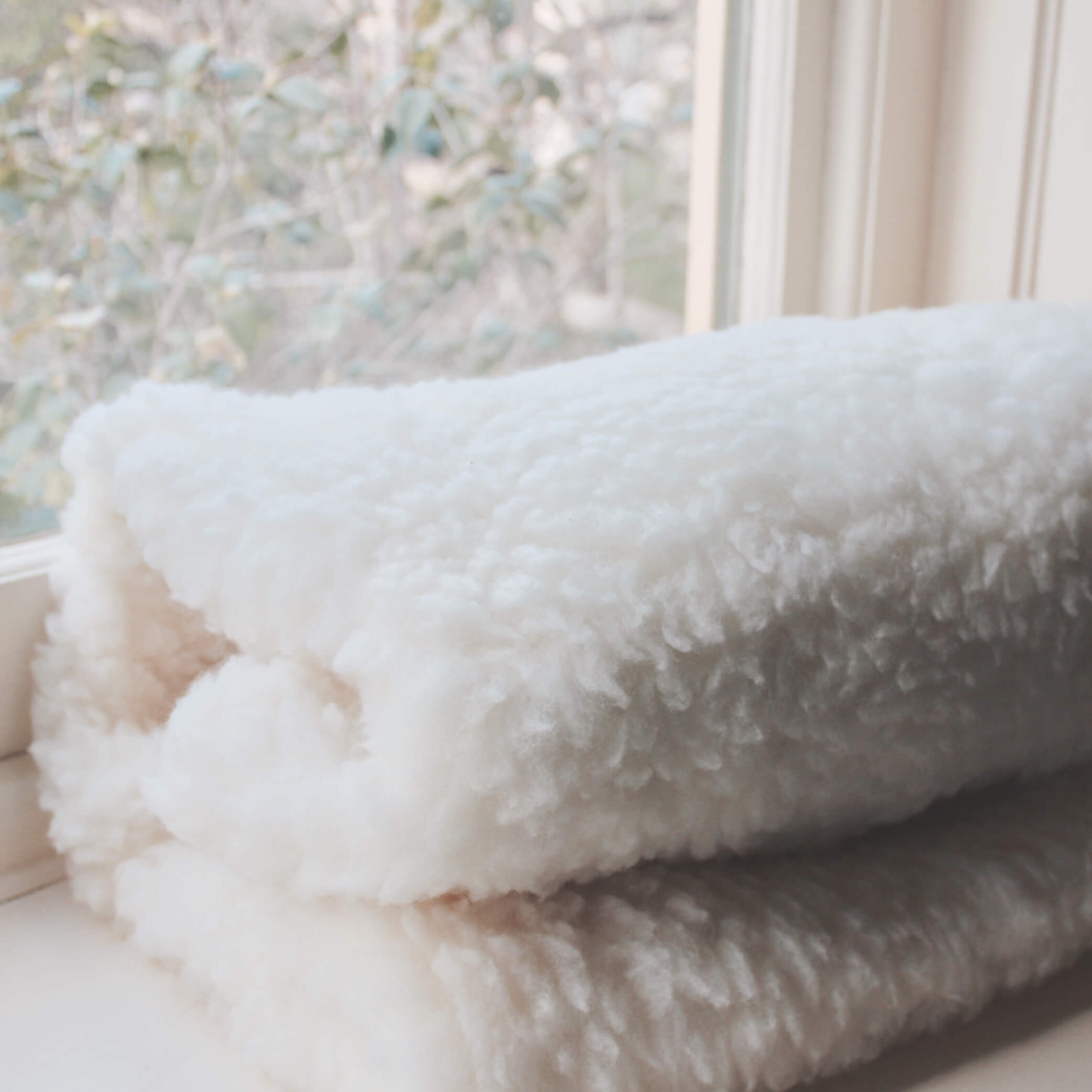 Mattress cot topper for babies made from Australian lambswool with waterproof underside.