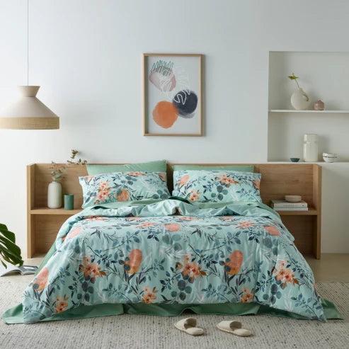 Bedroom featuring a luxurious water-resistant quilt cover set with a native Australian floral print in green and orange tones. 