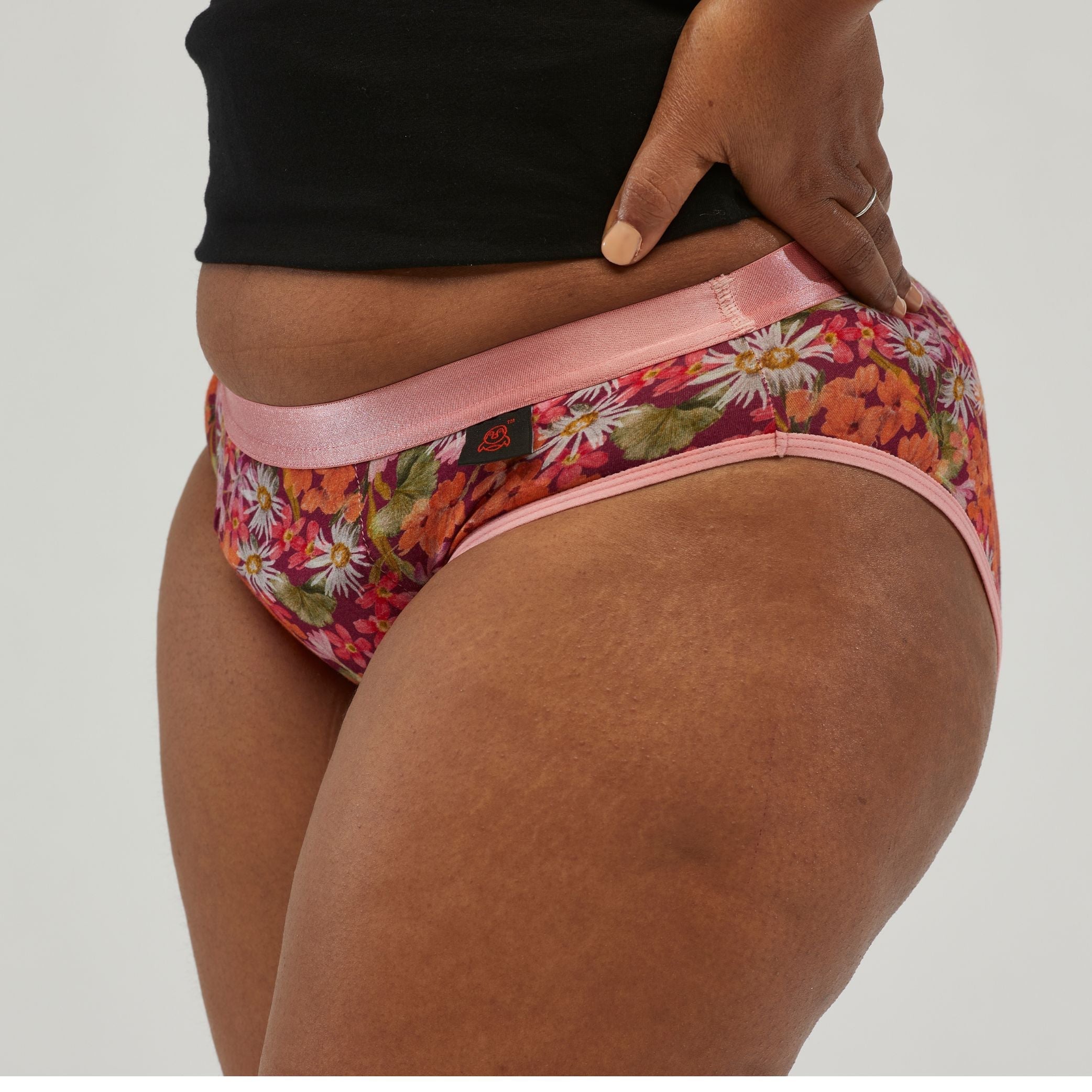 Side view of waterproof incontinence hipster underwear with a floral print and soft pink trim. Designed for superior leak protection and comfortable all-day wear