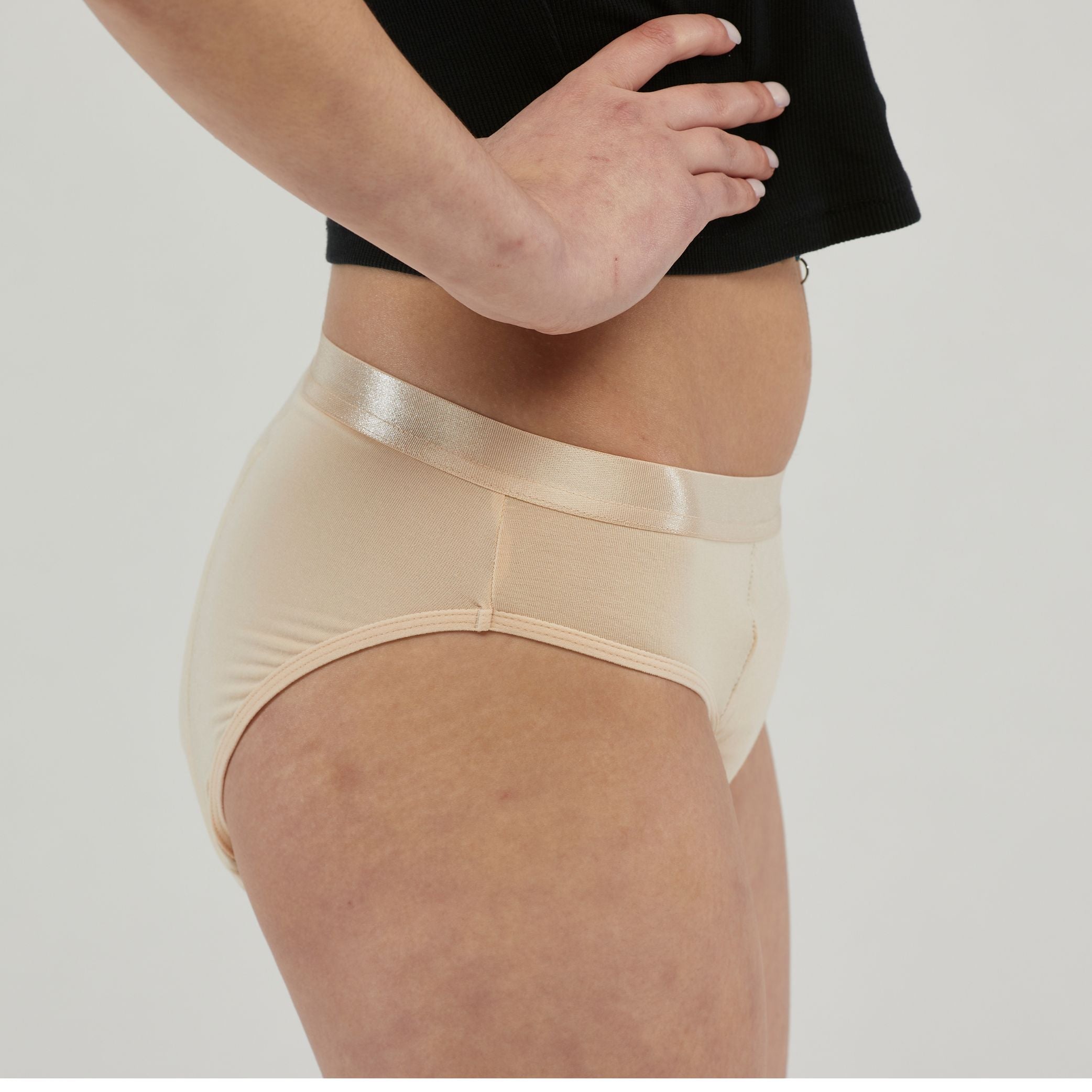 Side view of beige waterproof incontinence hipster underwear for women, featuring a leak-proof design and a satin waistband for all-day comfort and protection.