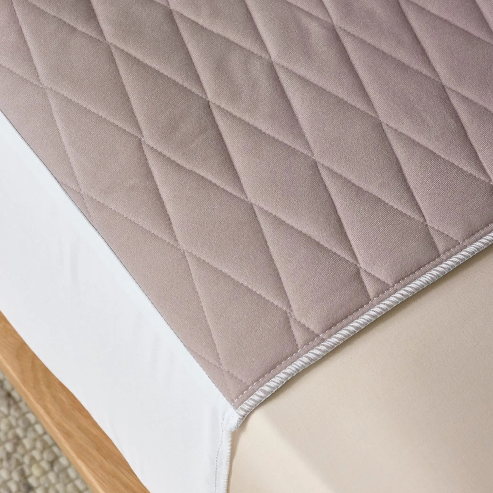 Close-up of a clay-coloured quilted waterproof kylie bed pad, designed for incontinence protection. Made from soft, breathable, and absorbent fabric with a secure fit to keep bedding dry and comfortable.