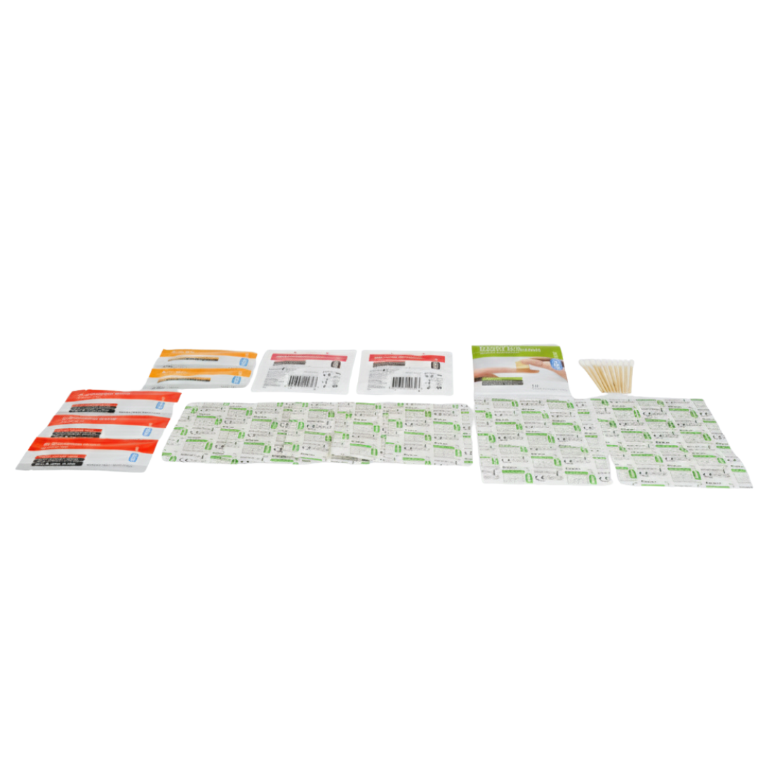 A flat-lay product image of the Companion First Aid Kit. The orange plastic carrying case is centered behind the contents, which are spread out below it on a neutral background. The visible items include packaged plasters (bandages) in green and white packets, packets of burn gel or wipes in orange and red, gauze/non-adherent dressings, and cotton swabs.