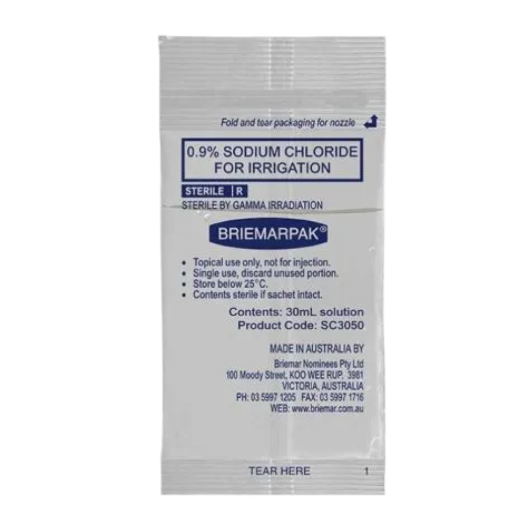 Close-up of a single 30mL Briemarpak 0.9% Sodium Chloride for Irrigation sachet detailing the usage instructions and manufacturer information.